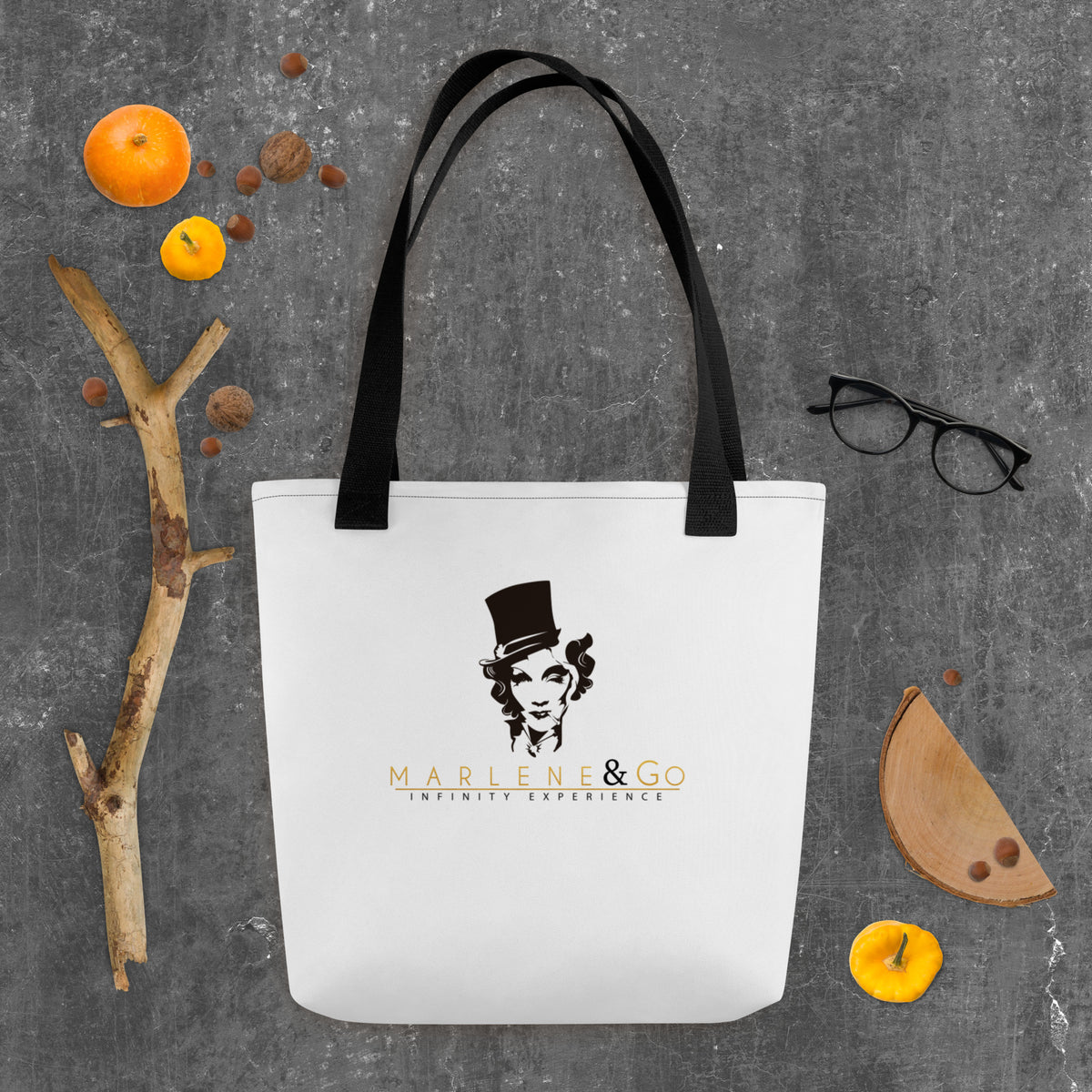 Marlene Crest Carry: bolsa blanca con emblema negro y dorado de Marlene y asas negras, vista frontal.
