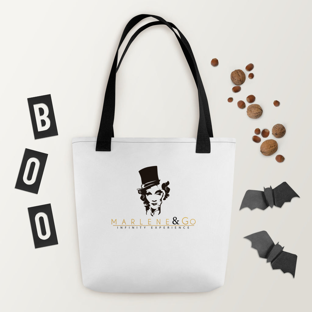 Marlene Crest Carry: bolsa blanca con emblema negro y dorado de Marlene y asas negras, vista frontal.