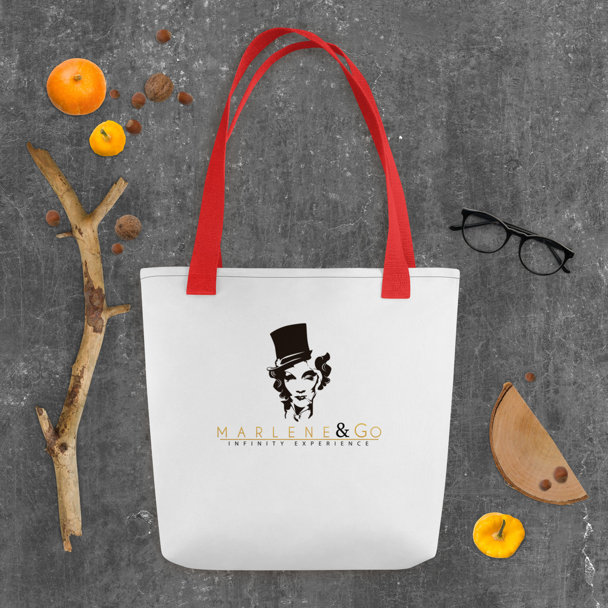 Marlene Crest Carry: bolsa blanca con emblema negro y dorado de Marlene y asas rojas, vista frontal.