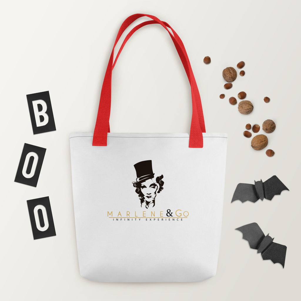 Marlene Crest Carry: bolsa blanca con emblema negro y dorado de Marlene y asas rojas, vista frontal.