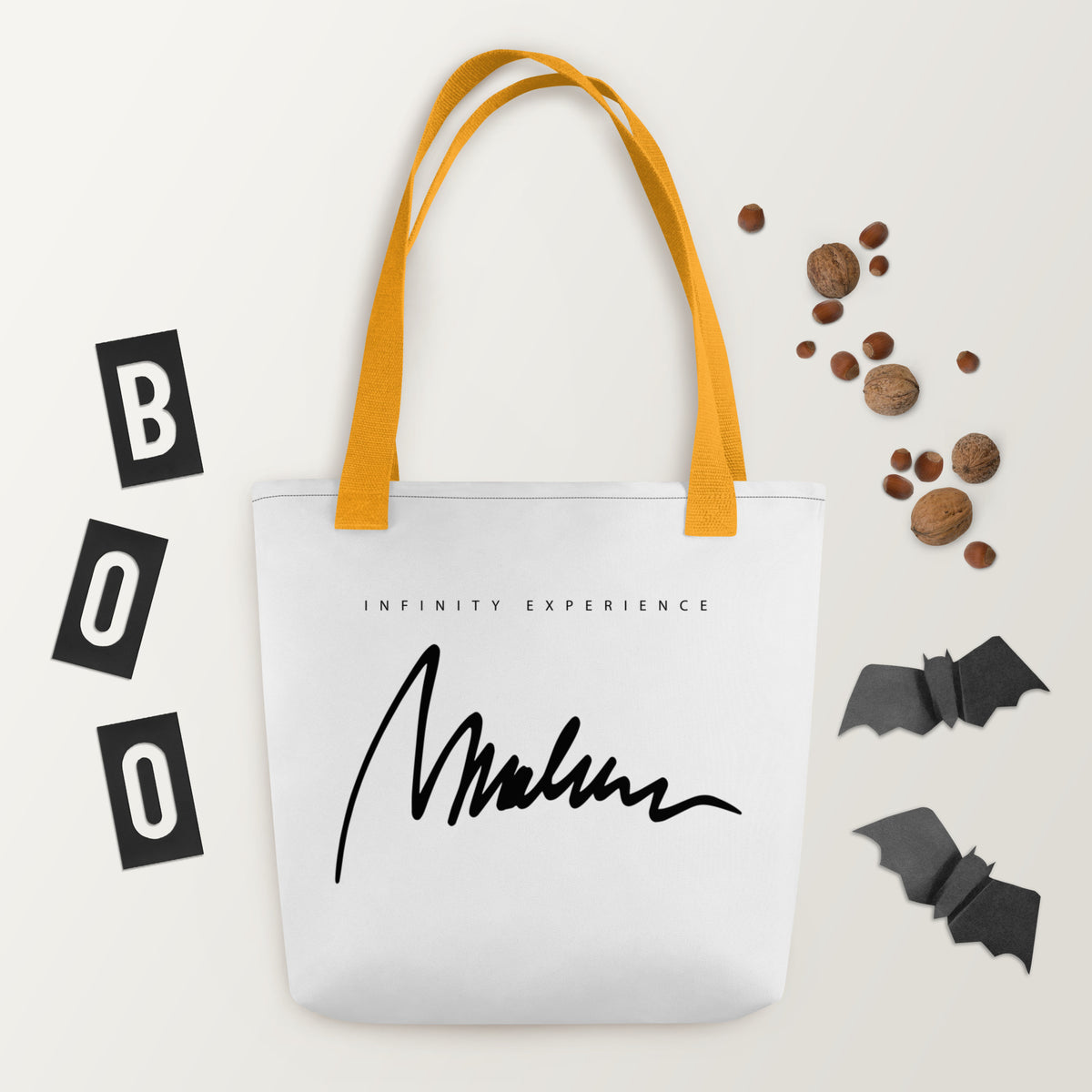 Marlene Crest Carry: bolsa blanca con firma negra Marlene en el reverso y asas amarillas.