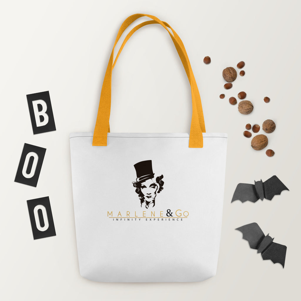 Marlene Crest Carry: bolsa blanca con emblema negro y dorado de Marlene y asas amarillas, vista frontal.