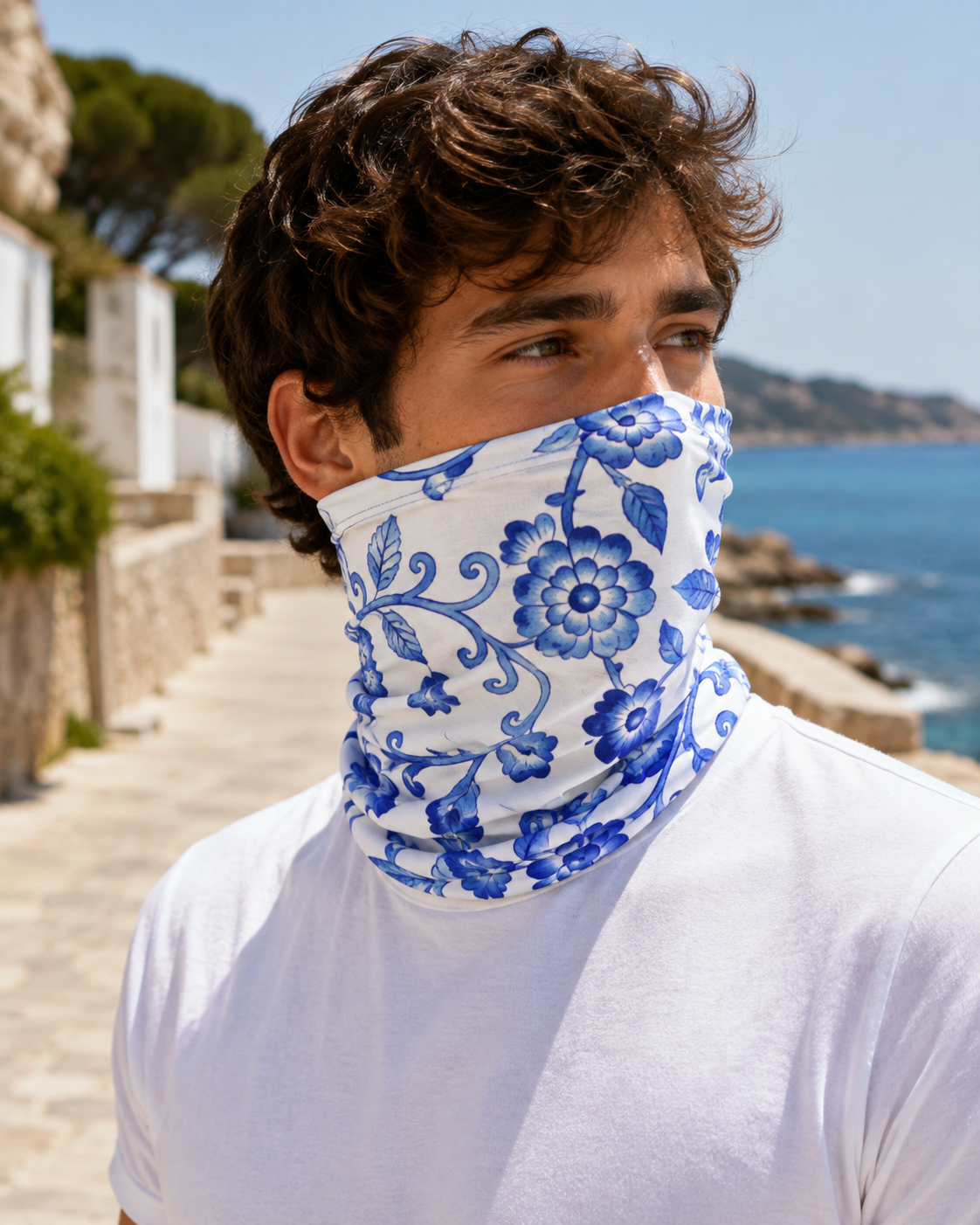 Hombre con braga de cuello Marlene Blue Bloom Pulse en la costa
