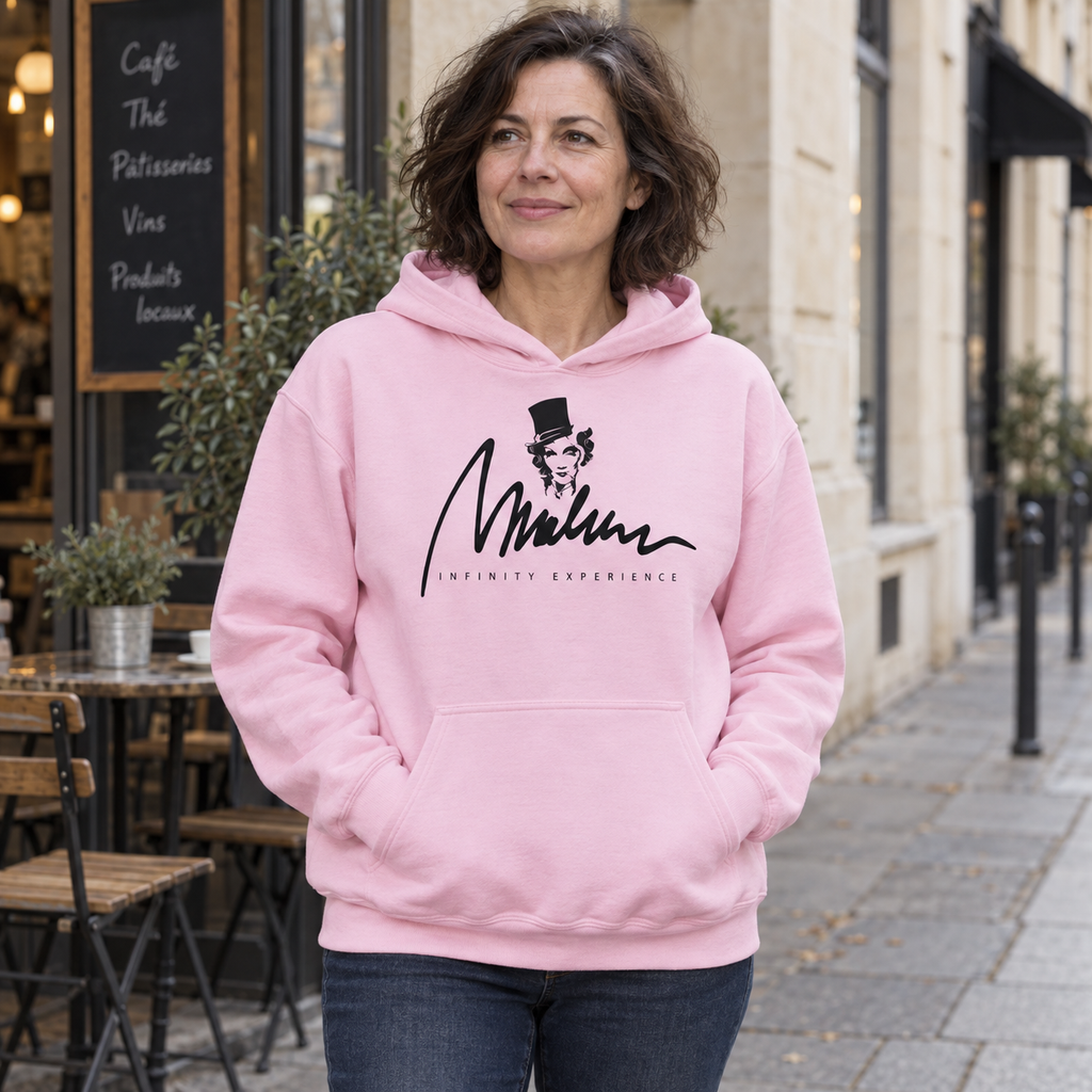 Rose Berlin: sudadera rosa claro con diseño original Marlene, llevada junto a una cafetería.